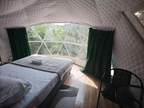 a bedroom with a bed and a large window at Zarati House 