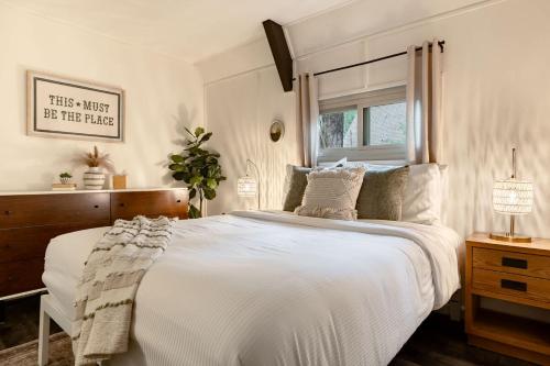 a bedroom with a large white bed with a window at Hotevilla A-Frame Cabin with Wi-Fi & Pine Tree Views in Flagstaff