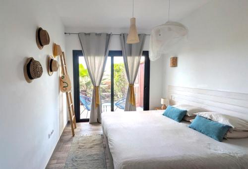 a bedroom with two beds with blue pillows at Casa Cocoon, Sun&Freedom, 8 mn from beaches, internet fiber in Lajares
