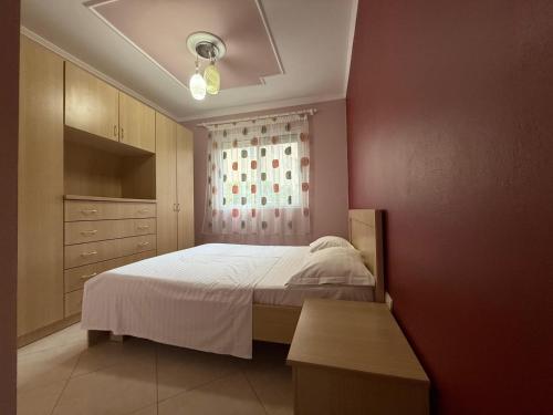 a bedroom with a white bed and a window at Daniels apartment in Shëngjin