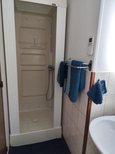 a bathroom with a shower with blue towels and a sink at Petite escapade dans le Perche 1 in Sainte-Céronne-lès-Mortagne
