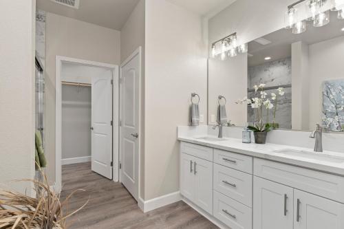 a white bathroom with two sinks and a mirror at Megginson Apartments in Dasmariñas