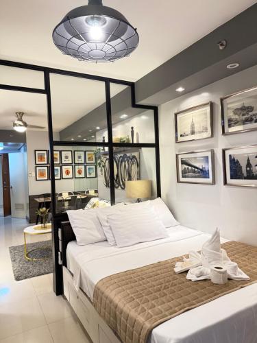 a bedroom with a large bed with white sheets at Shell Residences Condotel near Mall of Asia - Aiza's Place in Manila