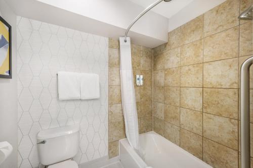 a bathroom with a toilet and a bath tub at Comfort Suites Albuquerque-North Journal Center in Albuquerque