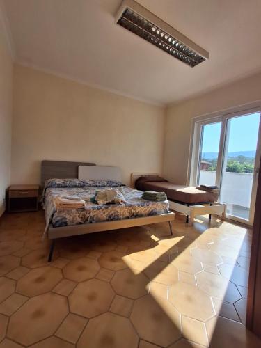 a bedroom with a bed and a chair and a window at Villa Verde in Ceccano