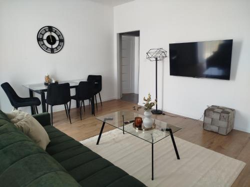 a living room with a green couch and a table at Apartmán VERDE in Suchá Hora