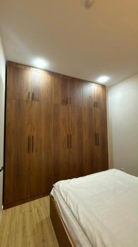 a bedroom with wooden cabinets and a white bed at next green in Makhinjauri