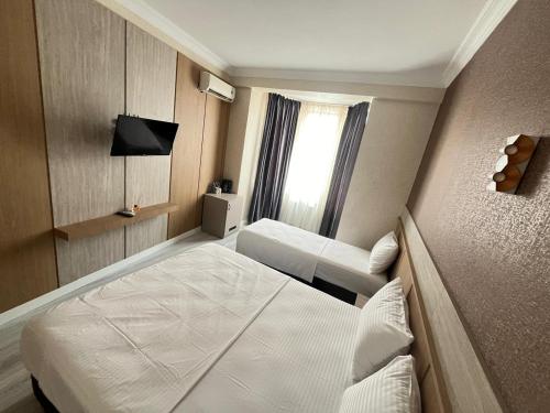 a hotel room with two beds and a window at Fortuna Hotel in Batumi