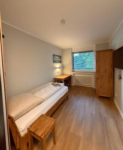 a bedroom with a bed and a desk and a window at City Event Hotel in Dinslaken