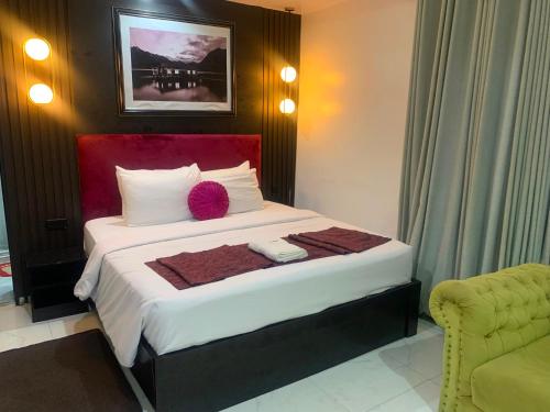a bedroom with a large bed with a red headboard at ffa resort centre in Akure