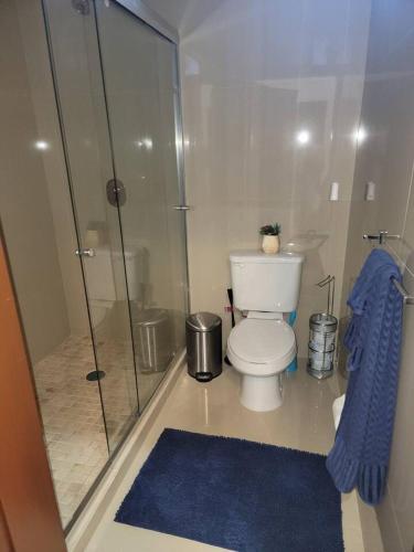 a bathroom with a toilet and a glass shower at 2BR-3BA Condo Block from Beach w Rooftop Jacuzzi in Mazatlán