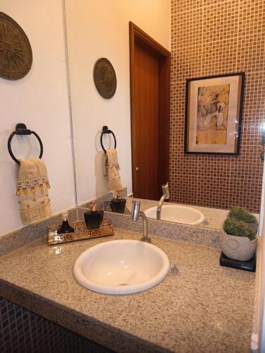 a bathroom counter with two sinks and a mirror at Rancho do Mirante in Araçatuba