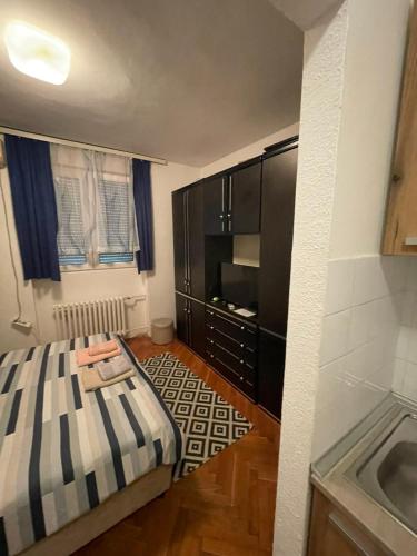 a small bedroom with a bed and a dresser at Аpartman CACA in Pančevo