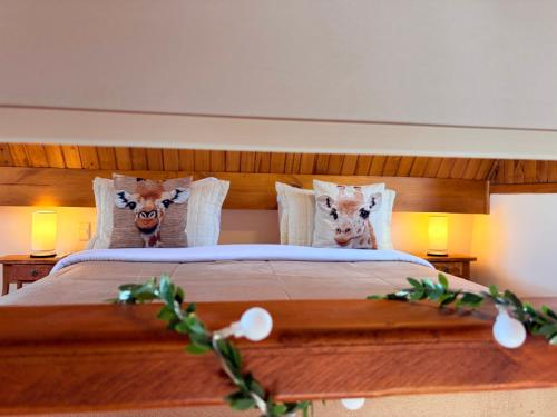 a bedroom with a bed with two animal heads on the pillows at Le Ville - Campos do Jordão in Campos do Jordão