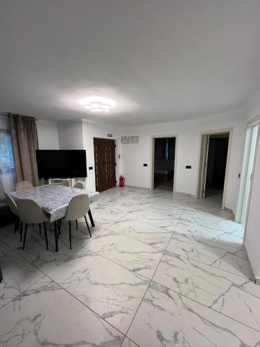 a living room with a table and chairs on a marble floor at Căsuța Găvruj in Săcel