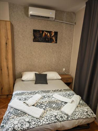 a bedroom with a bed with two towels on it at Niški kutak in Niš