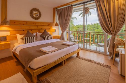 ein Schlafzimmer mit einem großen Bett und einem Balkon in der Unterkunft WaterCloud Mathiveri in Insel Mathiveri