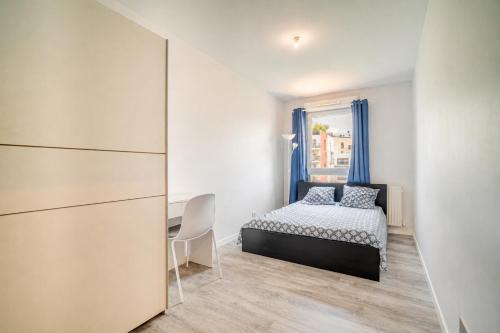 a bedroom with a bed and a desk and a window at Appart Standing in Trappes