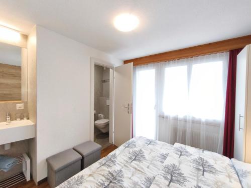 a bedroom with a bed and a sink and a toilet at Haus Primavera in Saas-Fee