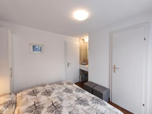 a bedroom with a bed and a door to a bathroom at Haus Primavera in Saas-Fee