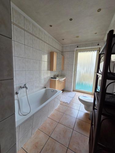 a bathroom with a tub and a toilet at Monteurwohnungen Santos Lerch in Krefeld