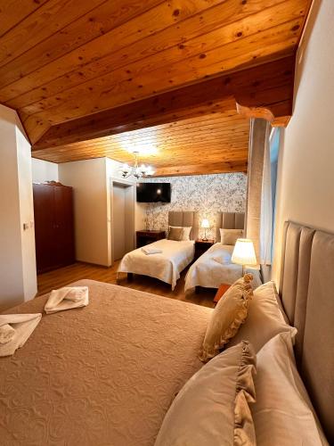 a bedroom with two beds and a wooden ceiling at Zielona Przystań - Noclegi in Maków Podhalański