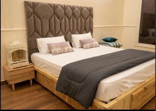 a large bed with a large headboard in a bedroom at Sukoon Farms in Greater Noida