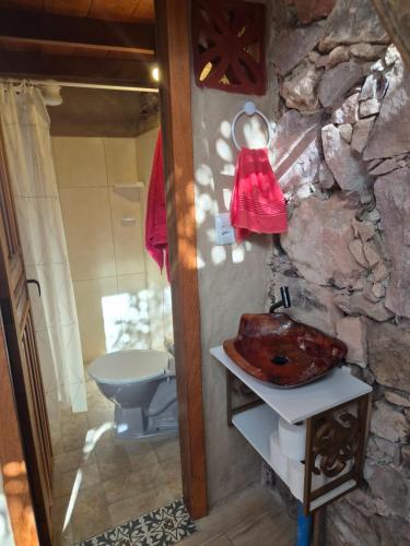 a stone bathroom with a sink and a toilet at JAGATÁ- Nossa comunidade in Igatu