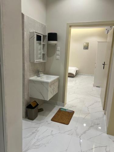 a white bathroom with a sink and a mirror at شاليهات الورد الفندقية in Ash Shuqayq