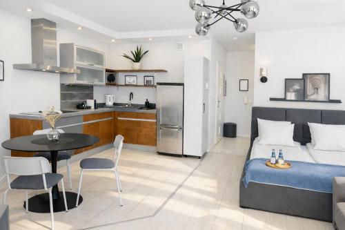 a living room and kitchen with a bed and a table at Kairos Apartments - Lothus - darmowy garaż podziemny, ścisłe centrum in Gliwice