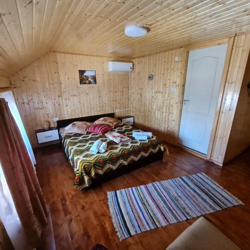 a bedroom with a bed in a room with a wooden ceiling at Casa Faurului in Valea Faurului