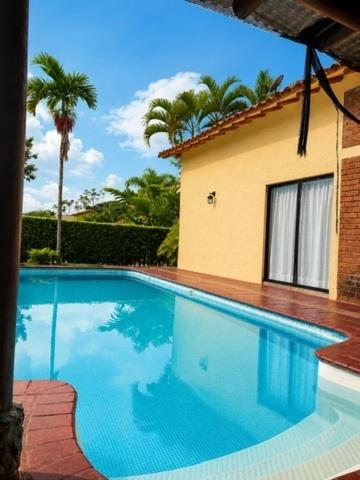 a large blue swimming pool next to a house at Fincas Panaca Herreria 23 in Quimbaya
