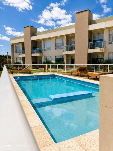 a swimming pool in front of a building at Agua de Vida- Parque Termal Chajarí in Chajarí