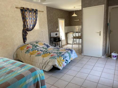 a bedroom with a bed and a kitchen at Meublé chocolat in Réaumur