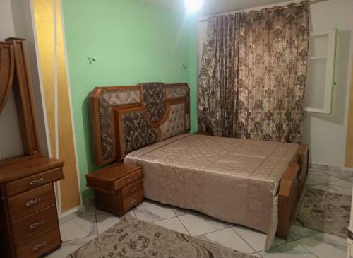 a small bedroom with a bed and a dresser at Dar Khuwayra in El Haouaria
