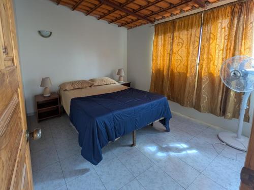 a bedroom with a bed and a fan and a window at Ponta Gato Residence in Tarrafal