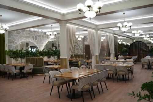 a dining room with tables and chairs and chandeliers at Zielona Przystań - Noclegi in Maków Podhalański