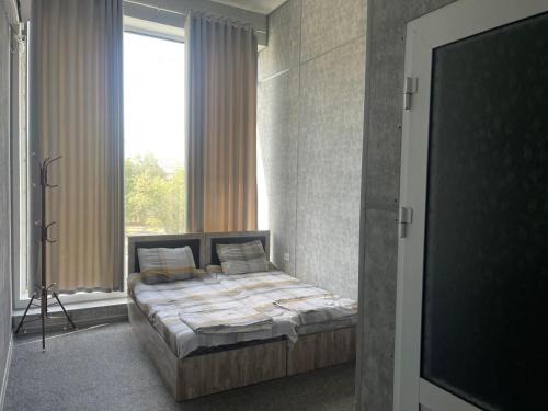 a bedroom with a bed and a large window at Shodlik Hotel 