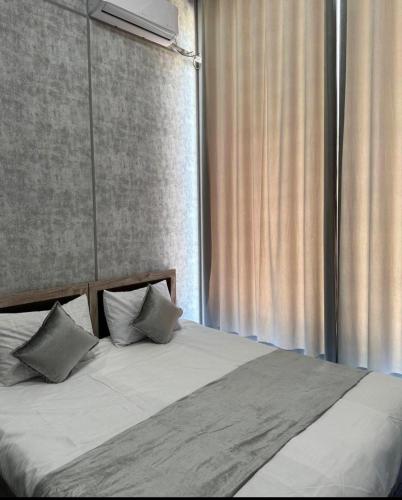 a bed with two pillows sitting next to a window at Shodlik Hotel 