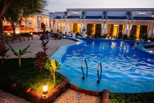 a large swimming pool in a resort with candles in it at Googles Beach Hotel Zanzibar in Zanzibar City