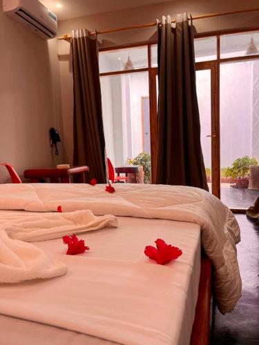 two beds in a room with red flowers on them at Googles Beach Hotel Zanzibar in Zanzibar City