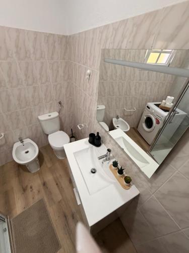 a bathroom with a sink and a toilet and a mirror at Casa Misarela in Ruivãis