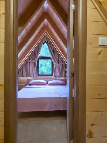 a bed in a room with a window at Vila Milena in Žabljak