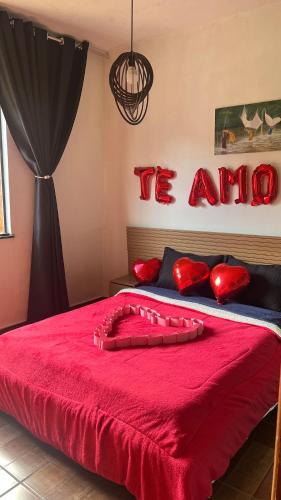 a bedroom with a red bed with the words tulum on the wall at Casa do Bosque in Paty do Alferes