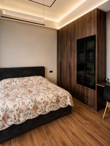 a bedroom with a bed and a wooden wall at Cozy family apartment at Seabreeze Nardaran, Beach & Pool, Polo Residence in Baku