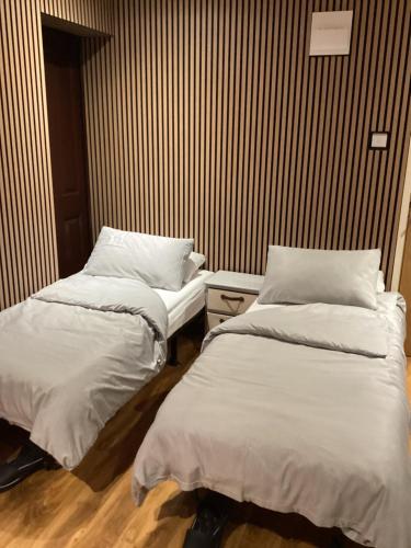 two beds sitting next to each other in a room at The Anfield Apartment in Liverpool