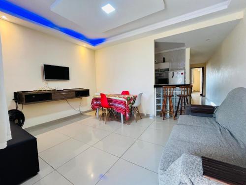 a living room with a couch and a table with red chairs at Casa Amarela de Praia in Maricá