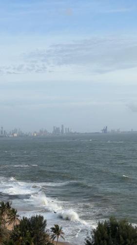 a view of the ocean with a city in the distance at Apartment Leeza in Uswetakeiyawa