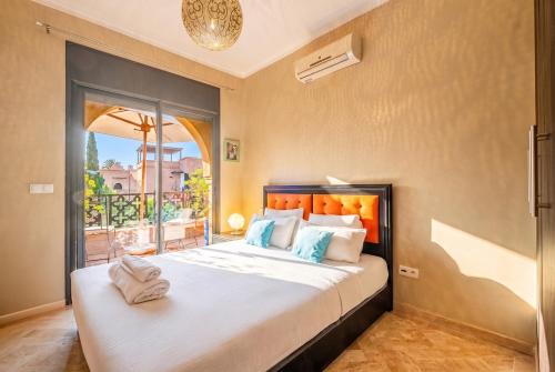 a bedroom with a large bed and a balcony at Atlas Golf Resort in Marrakesh