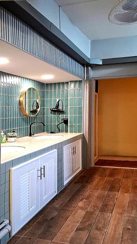 a bathroom with two sinks and a mirror at Sindy's Hostel in Pattaya